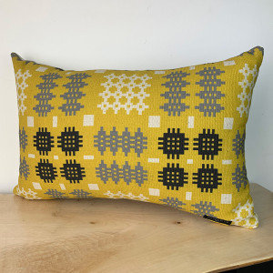 Image shows rectangle shaped cushions in Green, Yellow and Grey with a traditional Welsh Tapestry print design.