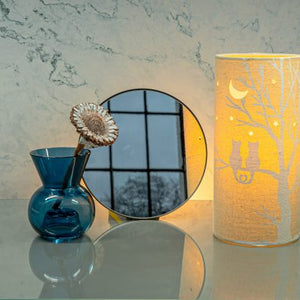 Image shows tube shaped beige fabric lamps with white Love cats designs painted on and cut out shapes which a warm light shines out of.