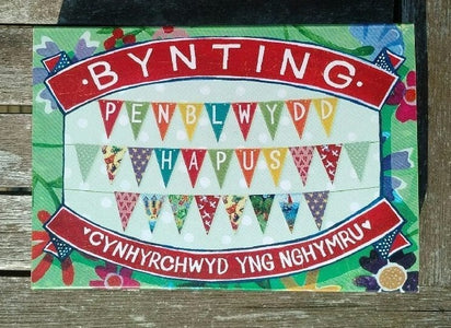 Image shows example of beautifully illustrated, colourful card bunting wich reads 'Penblwydd hapus'.